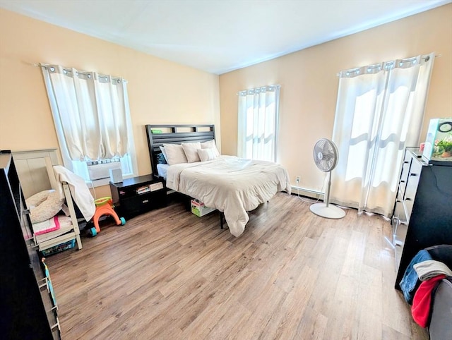 bedroom featuring a baseboard radiator and wood finished floors