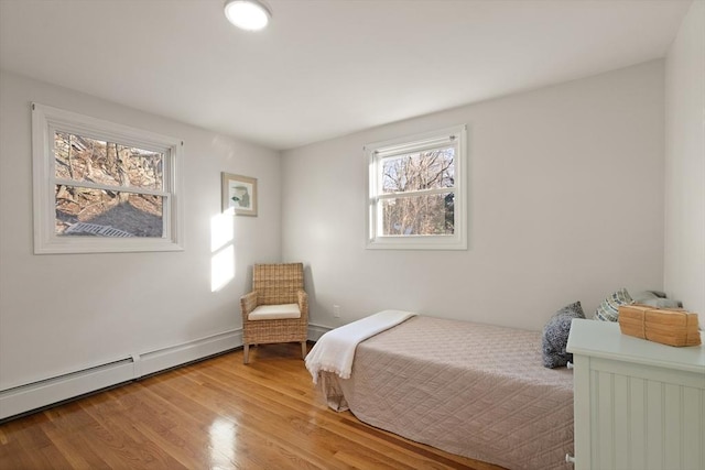 bedroom with a baseboard radiator and wood-type flooring