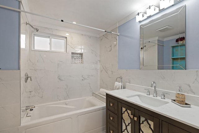 bathroom with tiled shower / bath, vanity, and crown molding