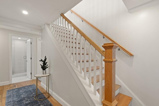 stairs with wood-type flooring and ornamental molding