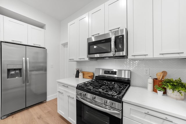 kitchen with light wood-type flooring, white cabinetry, stainless steel appliances, and decorative backsplash