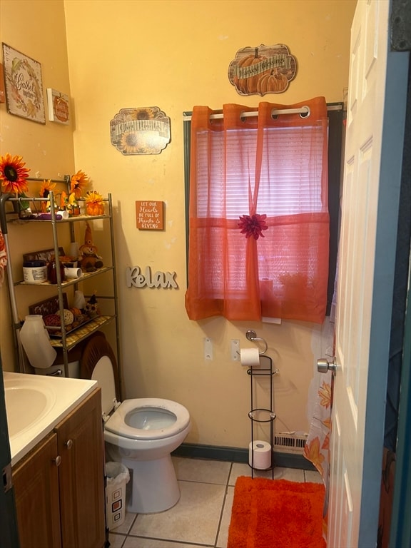 bathroom with toilet, vanity, and tile patterned flooring