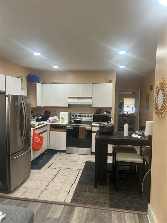 kitchen featuring appliances with stainless steel finishes, light hardwood / wood-style flooring, and white cabinets