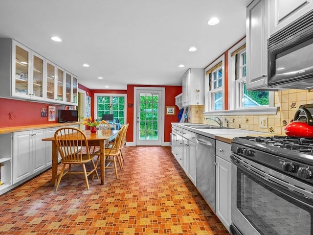 kitchen featuring stainless steel appliances, a sink, tasteful backsplash, white cabinets, and recessed lighting