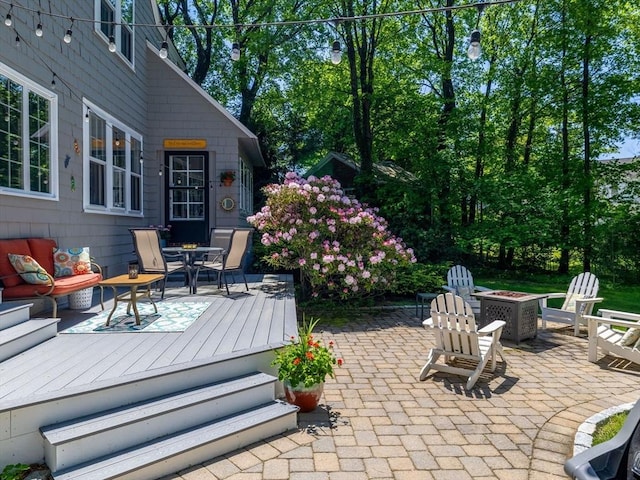 view of patio with a fire pit, a wooden deck, and outdoor dining space