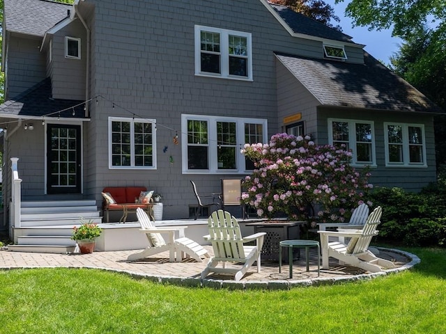 back of house with a patio, a shingled roof, and a lawn