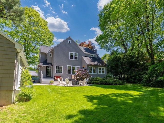 rear view of property featuring a yard and a patio area