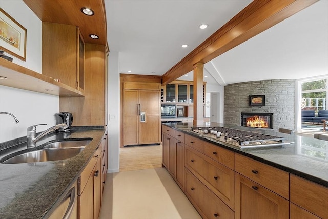 389 River Rd, Carlisle, MA 01741 - kitchen with stainless steel gas stovetop, paneled built in refrigerator, a stone fireplace, dark stone countertops, and open floor plan