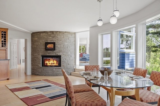 389 River Rd, Carlisle, MA 01741 - dining area with light wood-style floors, healthy amount of natural light, and a stone fireplace