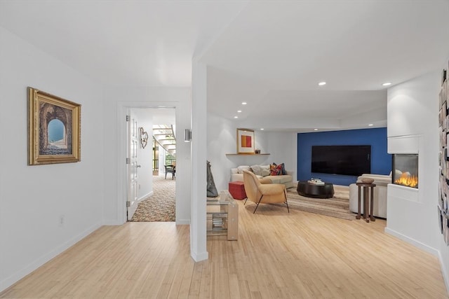 389 River Rd, Carlisle, MA 01741 - living room with light wood-style floors, a glass covered fireplace, and recessed lighting