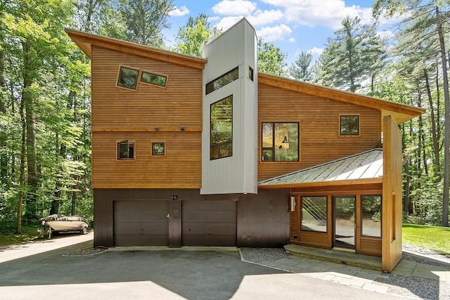 389 River Rd, Carlisle, MA 01741 - back of property featuring an attached garage, driveway, a metal roof, and a standing seam roof