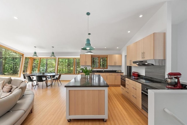 389 River Rd, Carlisle, MA 01741 - kitchen with light brown cabinetry, under cabinet range hood, dark countertops, open floor plan, and recessed lighting