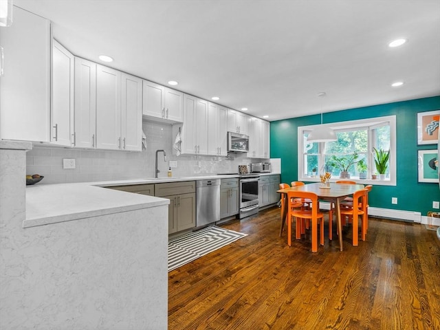 14 Belmont St Unit C, Somerville, MA 02143 - kitchen featuring appliances with stainless steel finishes, dark wood-type flooring, a baseboard radiator, light countertops, and backsplash