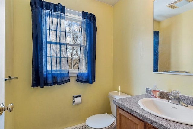 bathroom with toilet, visible vents, and vanity