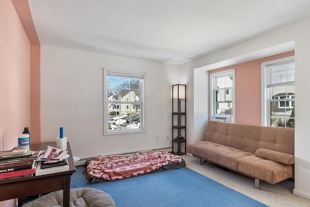 living area featuring baseboard heating and carpet flooring