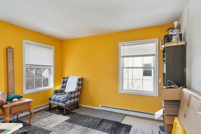 living area featuring carpet, a baseboard heating unit, and baseboards