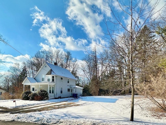 snow covered house featuring covered porch