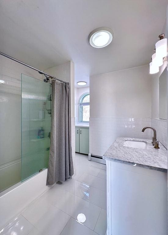 bathroom with tile patterned floors, tile walls, baseboard heating, vanity, and shower / bath combo with shower curtain