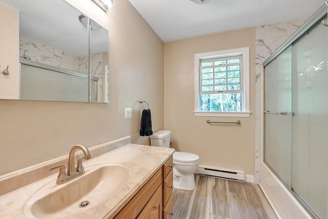 full bath with a baseboard radiator, toilet, wood finished floors, vanity, and bath / shower combo with glass door