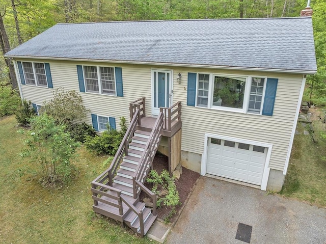 view of front of property featuring a garage, a shingled roof, a chimney, and asphalt driveway