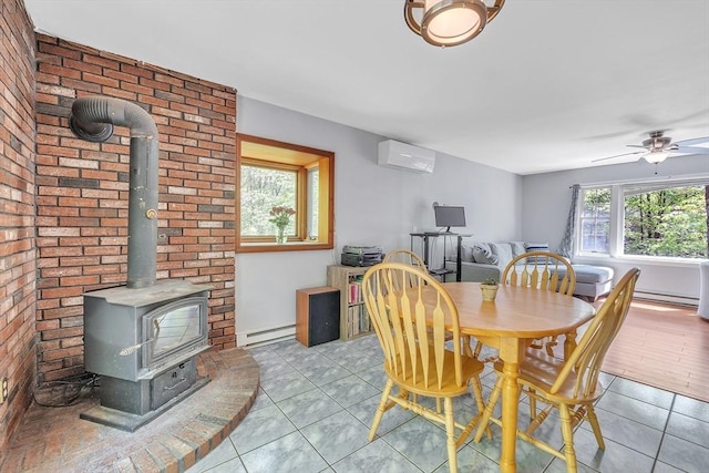 dining room featuring a wall mounted air conditioner, a baseboard heating unit, a wood stove, and light tile patterned flooring