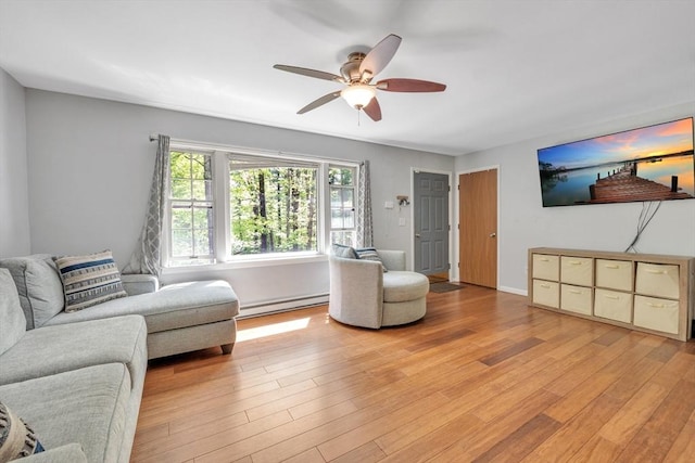 living area featuring a baseboard radiator, a ceiling fan, and light wood-style flooring