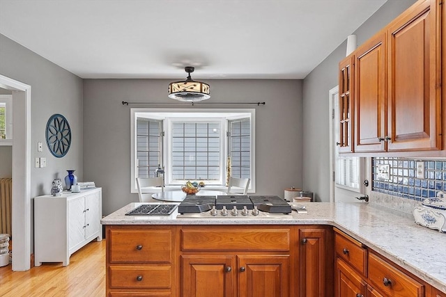 75 Hillcroft Ave, Worcester, MA 01606 - kitchen featuring brown cabinets, a peninsula, light stone countertops, and light wood finished floors
