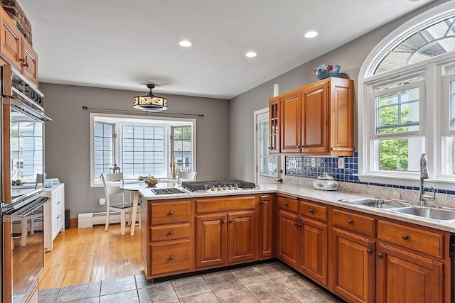 75 Hillcroft Ave, Worcester, MA 01606 - kitchen featuring a sink, light countertops, a baseboard heating unit, brown cabinets, and recessed lighting