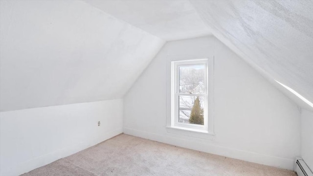 bonus room with a baseboard radiator, lofted ceiling, and light colored carpet