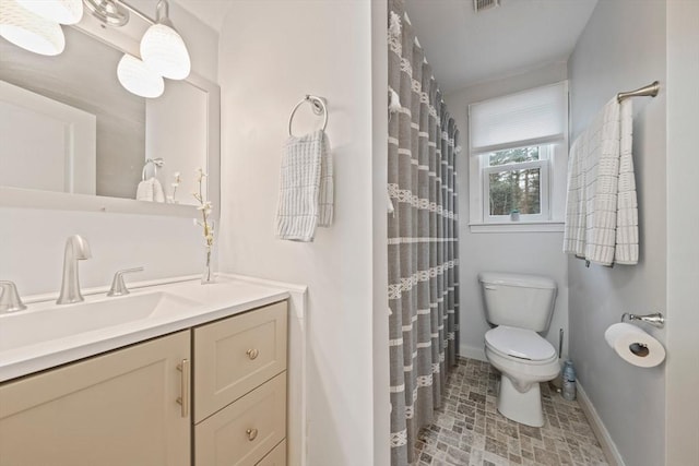 bathroom featuring vanity, toilet, and walk in shower