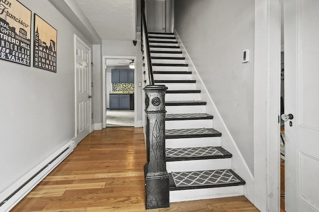 160 Regan St, Gardner, MA 01440 - stairway featuring a baseboard radiator, wood finished floors, and a ceiling fan
