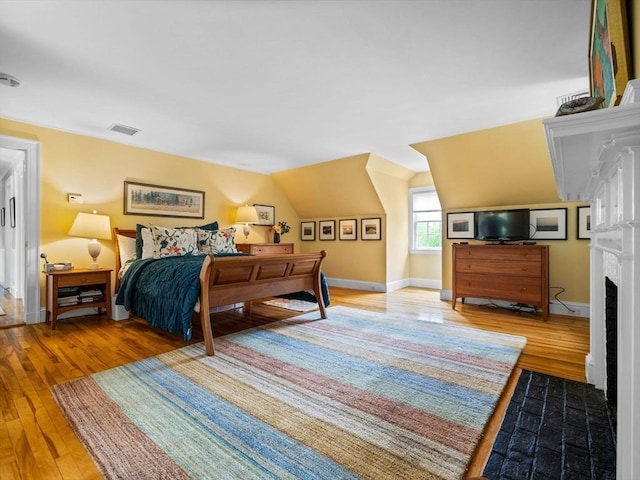 90 Burr Dr, Needham, MA 02492 - bedroom with wood finished floors, a fireplace with flush hearth, and lofted ceiling