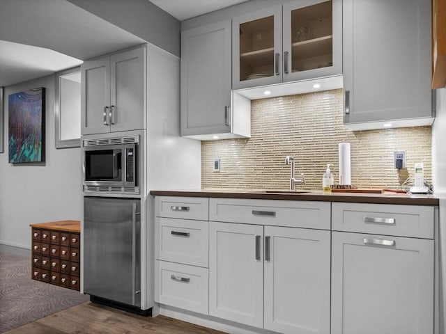 90 Burr Dr, Needham, MA 02492 - kitchen featuring stainless steel microwave, refrigerator, dark wood finished floors, and decorative backsplash