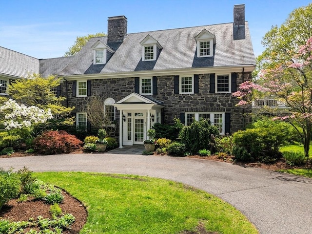 90 Burr Dr, Needham, MA 02492 - view of front of home featuring a chimney, stone siding, and a high end roof