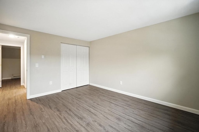 2 Maple Crest Cir Unit F, Holyoke, MA 01040 - unfurnished bedroom featuring dark wood-type flooring, a closet, and baseboard heating