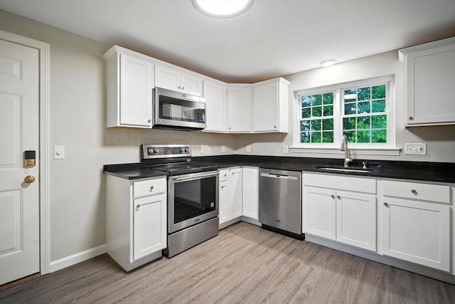 2 Maple Crest Cir Unit F, Holyoke, MA 01040 - kitchen with appliances with stainless steel finishes, light wood-type flooring, white cabinetry, and dark countertops