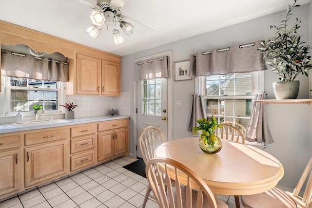 kitchen featuring ceiling fan, sink, decorative backsplash, light brown cabinetry, and light tile patterned flooring