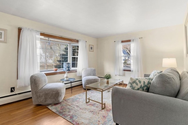 living room with baseboard heating and light hardwood / wood-style floors