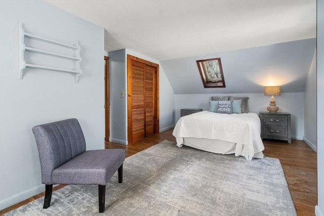 bedroom featuring hardwood / wood-style floors, vaulted ceiling, and a closet