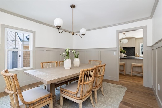 dining space with hardwood / wood-style flooring and ornamental molding