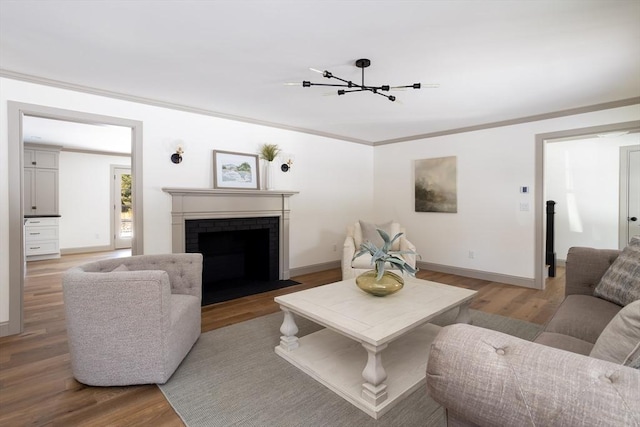 living room featuring a brick fireplace, ornamental molding, and light hardwood / wood-style floors