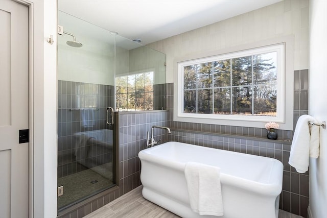 bathroom with tile walls and plus walk in shower