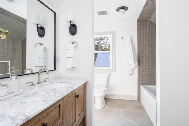 bathroom featuring lofted ceiling, a bathtub, vanity, toilet, and tile patterned floors