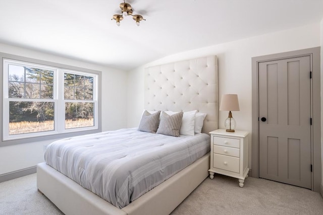 bedroom with lofted ceiling and light colored carpet