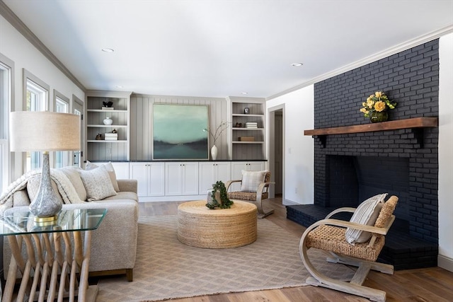 living room with crown molding, hardwood / wood-style flooring, and a fireplace