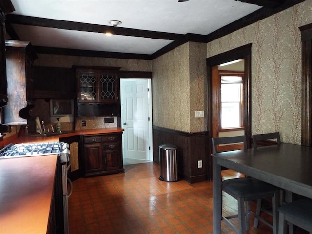 67 Gardner, Boston, MA 02132 - kitchen featuring wainscoting, wallpapered walls, stainless steel range with gas cooktop, dark brown cabinets, and wood walls