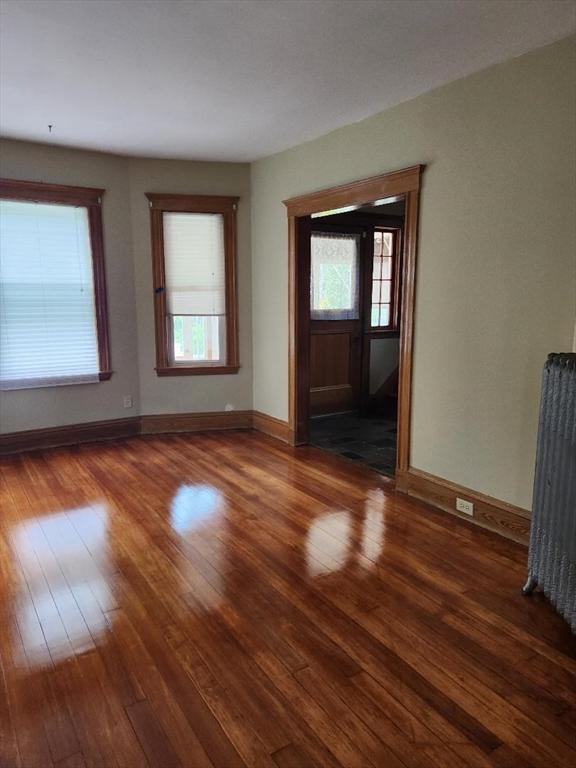 67 Gardner, Boston, MA 02132 - unfurnished living room with hardwood / wood-style flooring, plenty of natural light, and baseboards