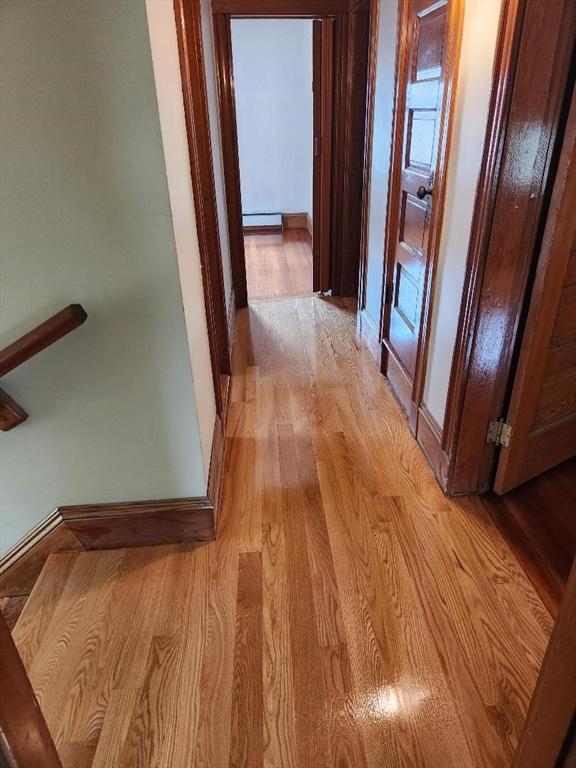 67 Gardner, Boston, MA 02132 - hallway featuring light wood-style flooring, a baseboard heating unit, and baseboards