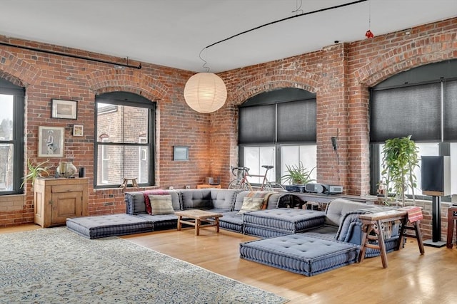 living room with brick wall and wood finished floors