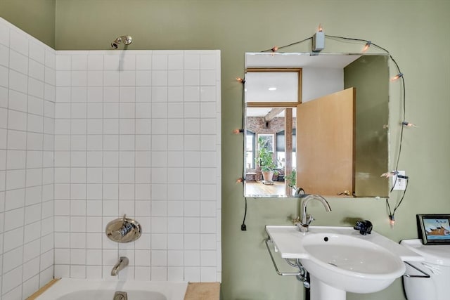 full bath featuring washtub / shower combination and a sink